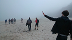 people walking on a beach in the mist